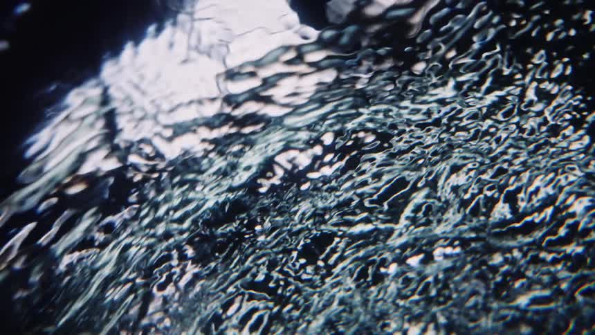 Light reflects on ripples in the water as it splashes and moves