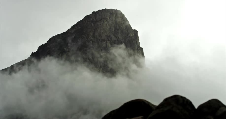 Timelapse of clouds clearing out revealing a towering granite mountain on Baffin Island