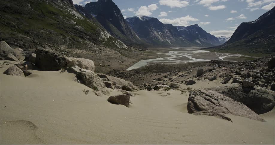Walking over the sand on the slopes of a valley near a river in the massive granite mountains of Baffin Island