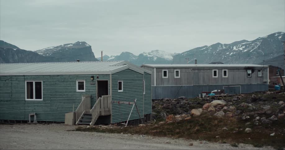 Houses with towering granite peaks and glaciers on Baffin Island