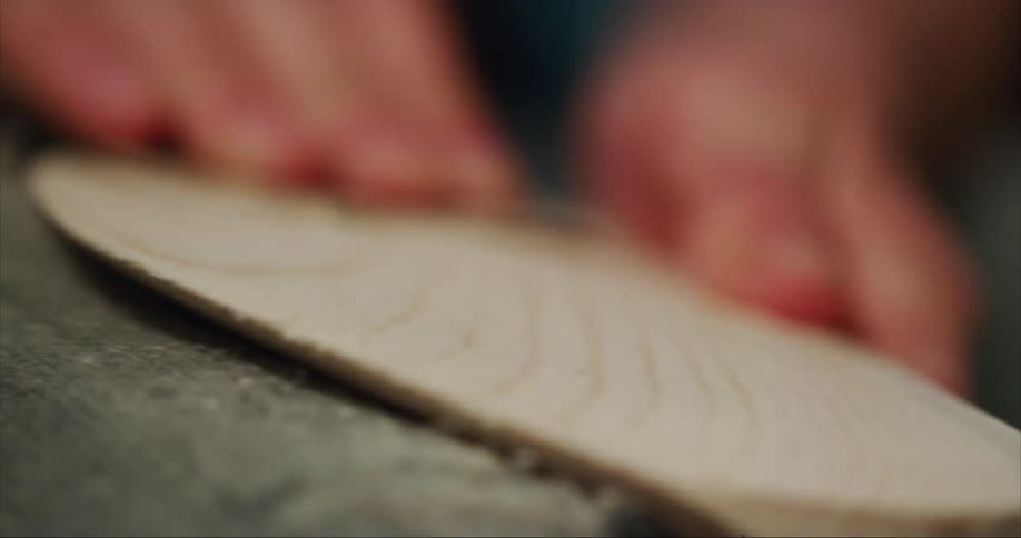 Close up of hands sanding wood while building a traditional Inuit style sea kayak