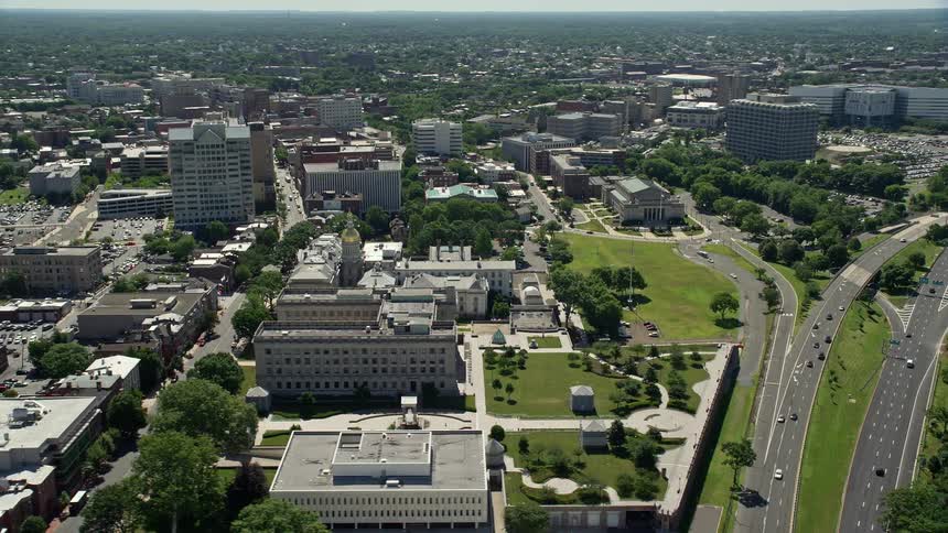An aerial view of Trenton New Jersey including the State House War Memorial park and office buildings on a sunny day
