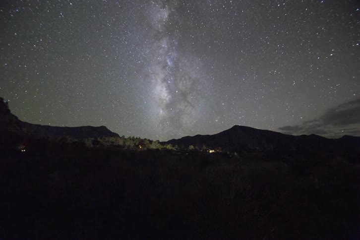 Lights flash over a hilly area at night