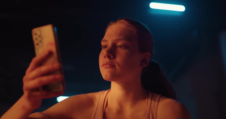 A young woman looks worried as she looks at her phone