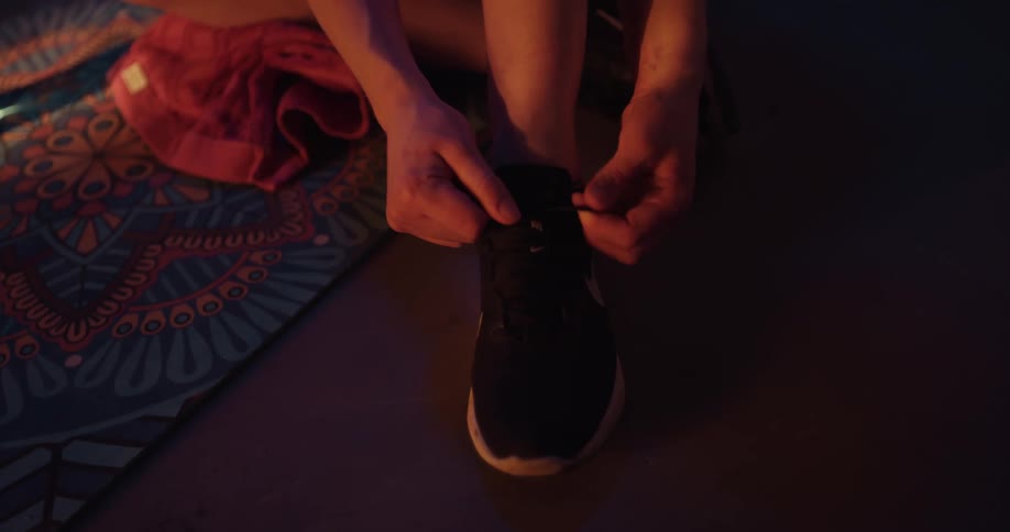 Woman ties shoelaces at the gym