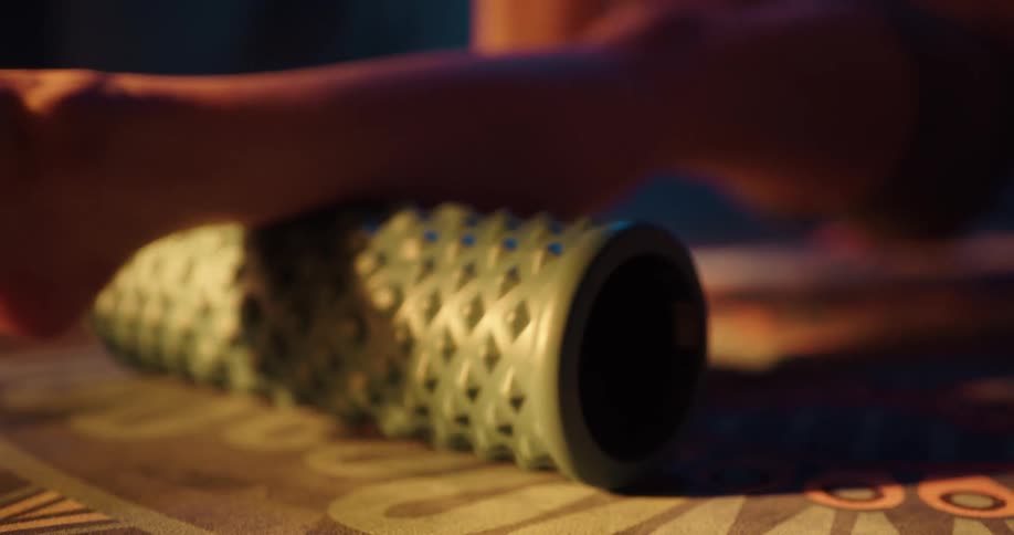 Woman wearing shorts uses yoga roller in a gym