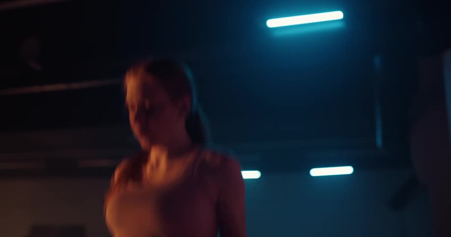 Redhead jumps rope in dimly lit gym