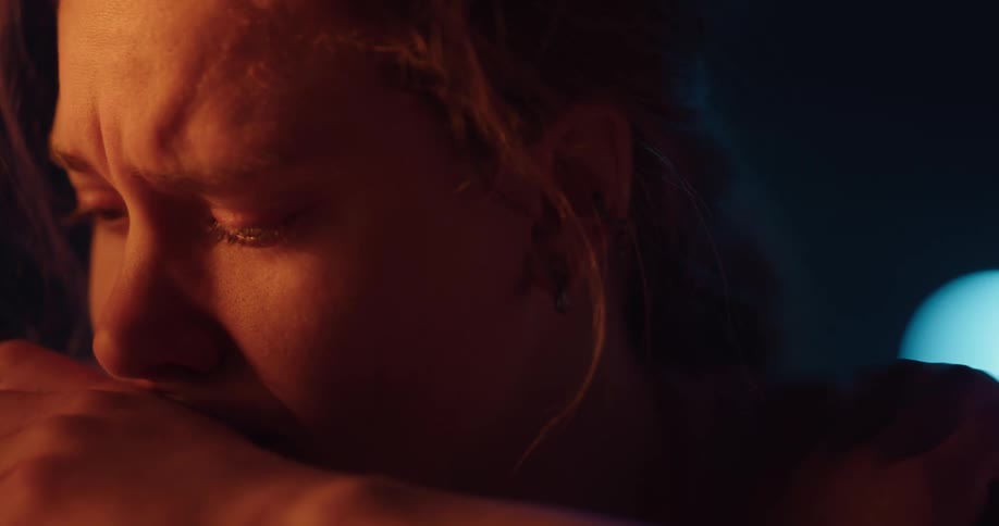 A young woman crying and rocking back and forth