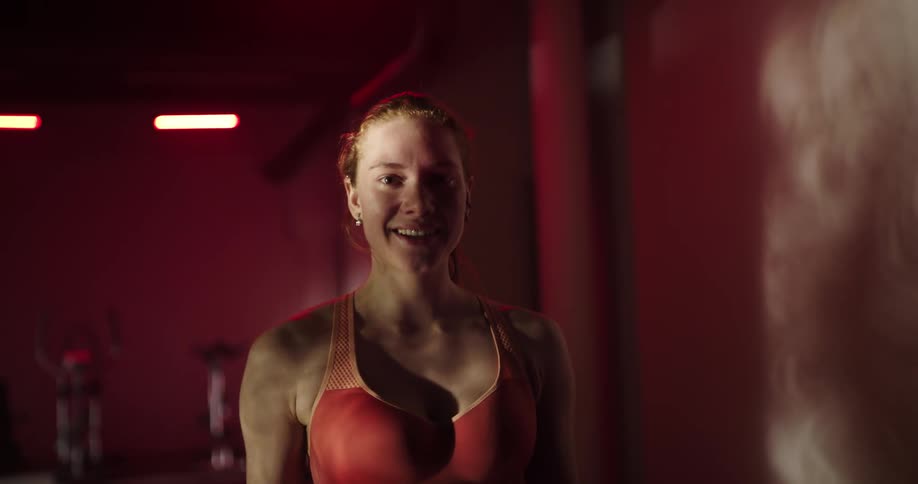A woman smiles as she walks in a gym