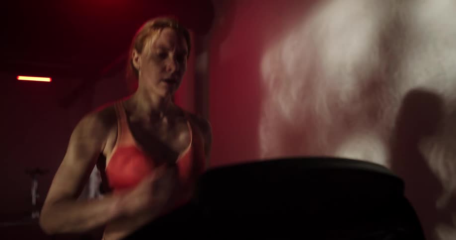 Woman running on treadmill casts shadow on wall