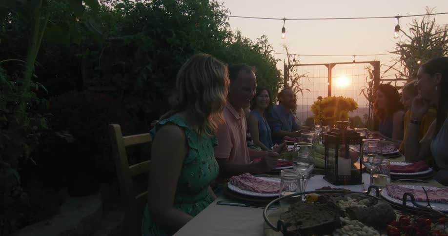 A group of people are having dinner outside on the farm
