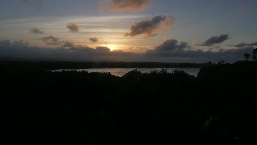 The sun comes up over a lake