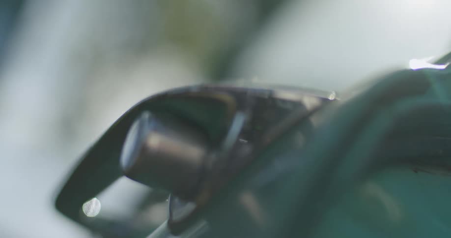 Old style car door handle sits on blue green door