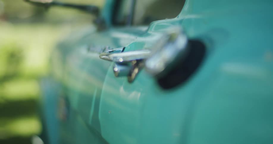 A mint green antique car parked outside