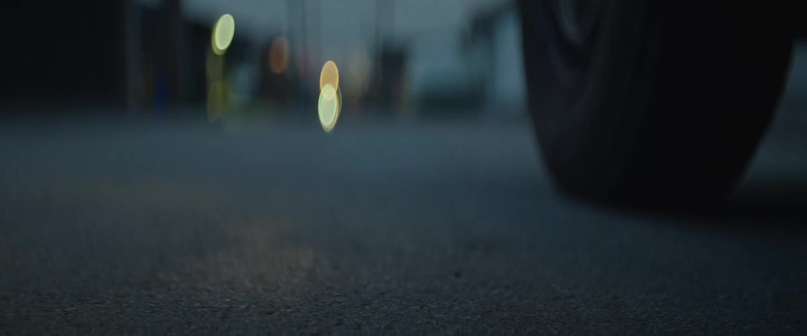 A persons foot hits the pavement as they get out of an automobile
