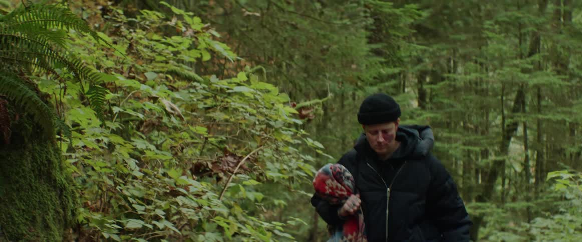 A woman carrying a blanket while hiking alone in a forest