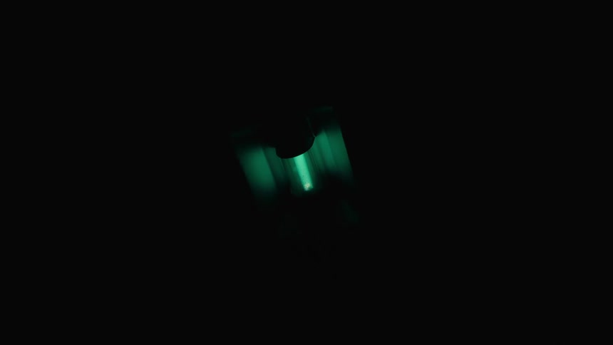 Light tube flickers on in darkness and ring slides up and down on machine