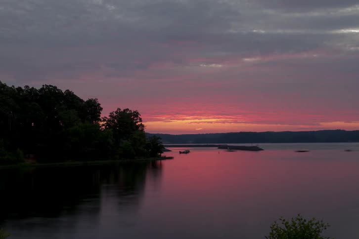 The sun rises over a pond