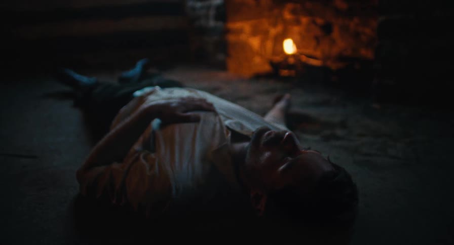 A depressed man lies on the floor near a fireplace