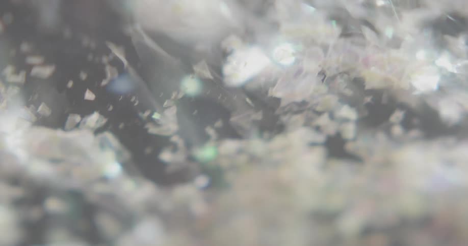 Red tinted shards are removed from black surface before more are dumped