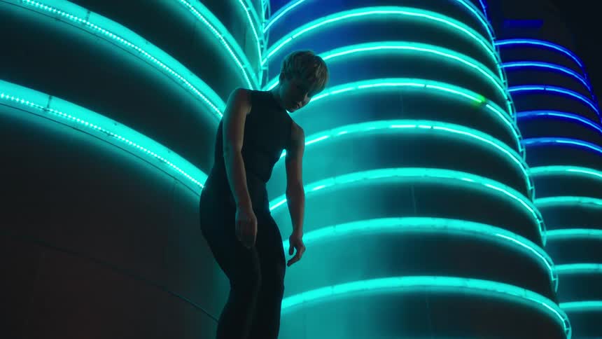 Girl standing up behind lighted columns