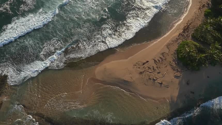 Waves roll ashore on a narrow beach
