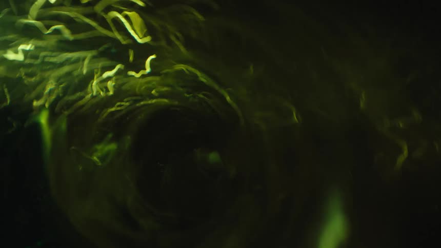 Green walled vortex spins as brighter green ribbons and streaks dance along edges
