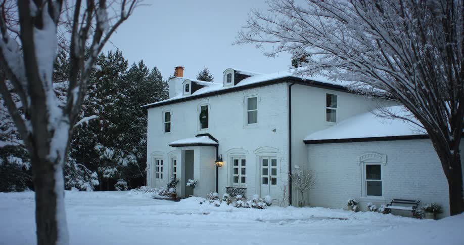 A thick blanket of snow covers the ground in front of home