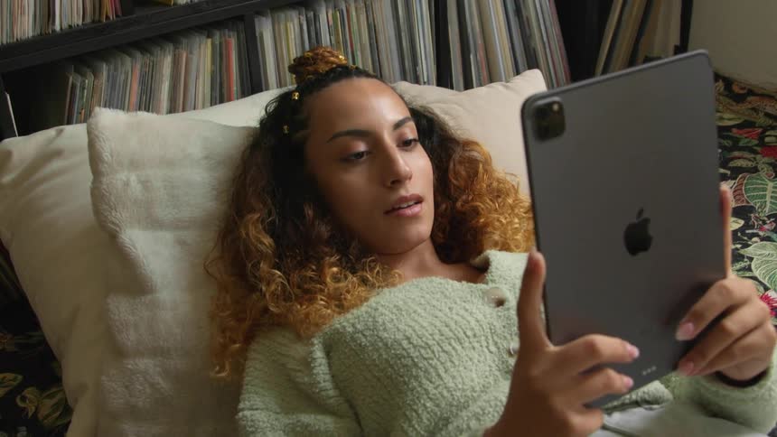A woman using a tablet in bed