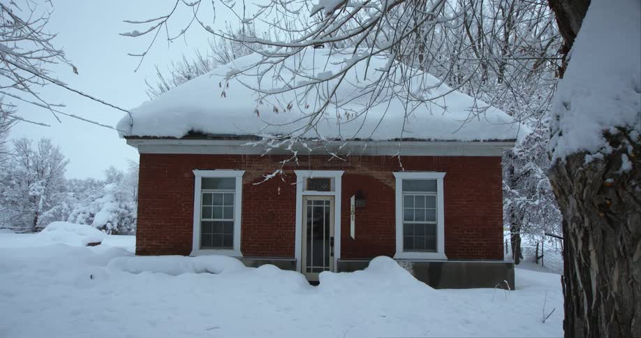 A house in a neighborhood is surrounded by snow