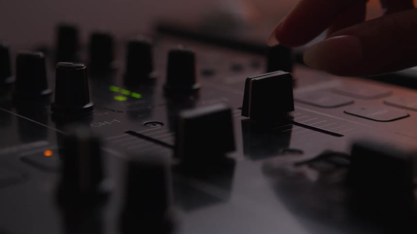 A view of a person using knobs on a mixer