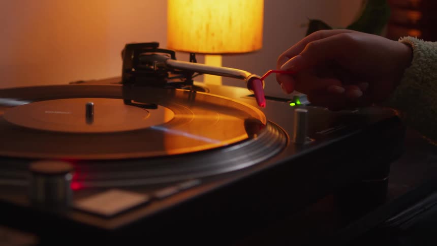 A person putting a needle on a record player