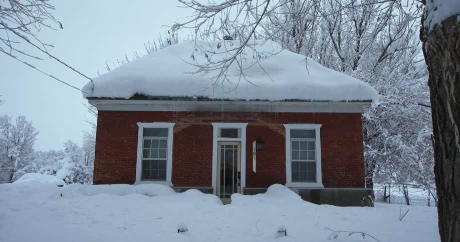 A snow covered red brick house
