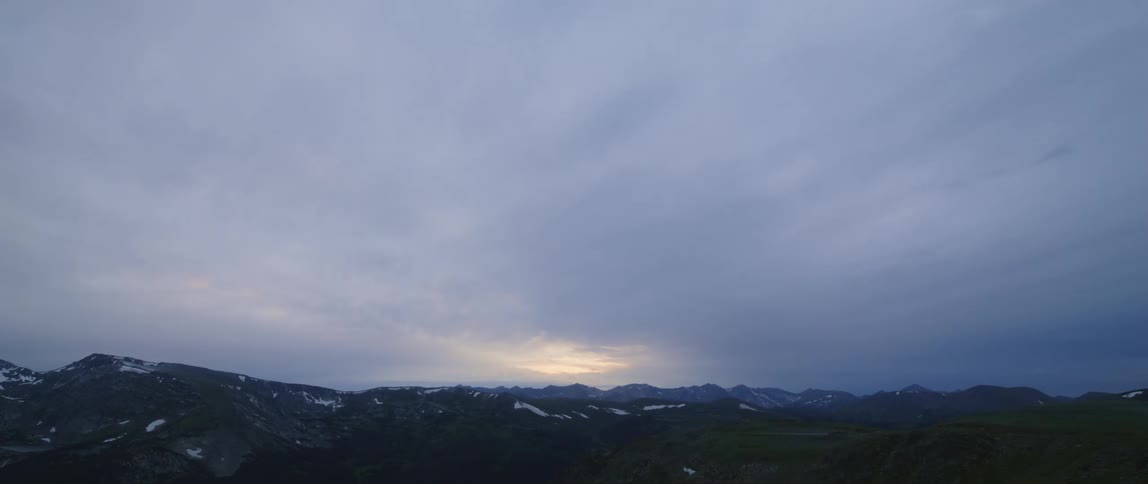 Time lapse of vehicles driving on a road near the mountains at evening