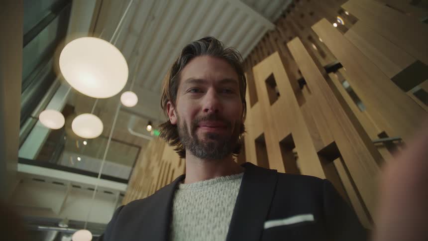 A man is smiling and looking at a screen