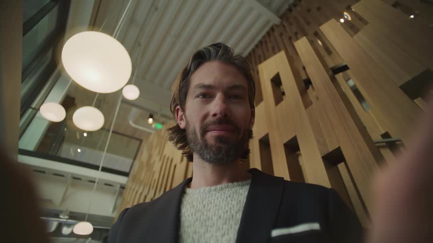 A man typing on his phone smiling