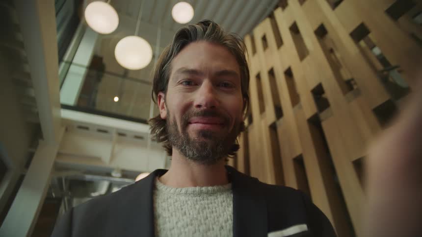 A man interacting with a device by tapping on the camera