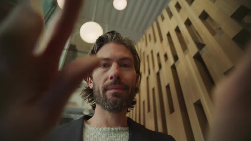 A man swiping on a device while walking through an office space