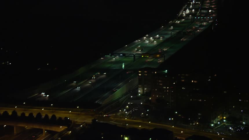 Aerial footage of Woodrow Wilson Memorial Bridge and Interstate 95 at night panning across Maryland and Virginia