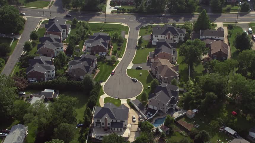 Approaching and tilting to a birds eye view of a suburban cul-de-sac and homes in Annandale Virginia during the summer day