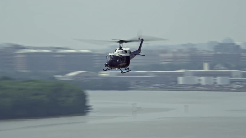 A helicopter flies over the Potomac River near Alexandria Virginia on a hazy day in the summertime