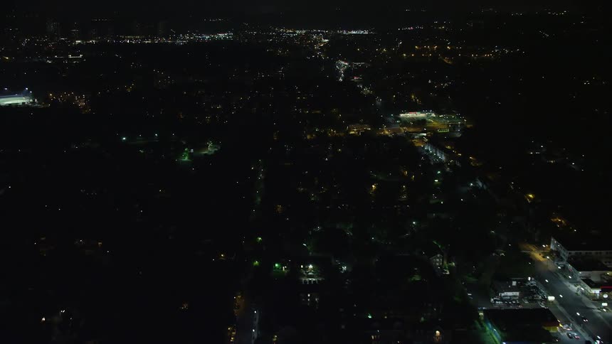 An aerial clip showcasing nighttime approach to a car dealership and shops on Columbia Pike in the residential suburb of Arlington Virginia