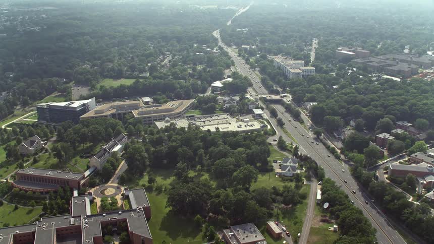 Aerial footage flying over suburban homes to approach an elementary school and government office buildings in Arlington Virginia during daytime