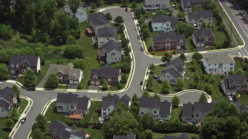 Aerial footage of suburban homes by quiet streets in Fairfax Virginia during the summertime