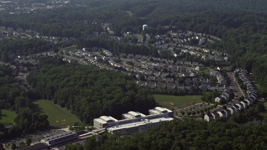 Aerial footage captures suburban homes on curved streets in Manassas Virginia on a summer day