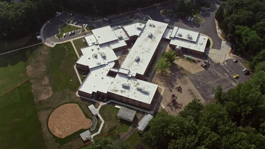 An aerial view of Canterbury Woods Elementary School in Annandale Virginia during a sunny day with a tilting birds eye perspective