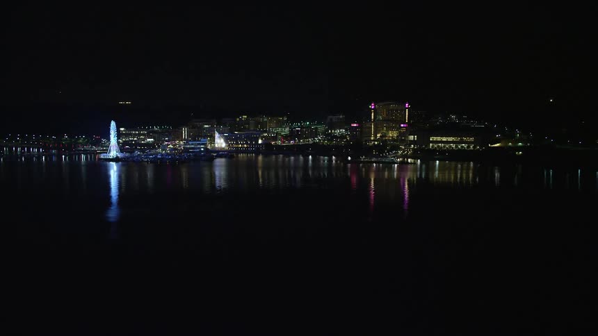 Approaching the brightly lit Capitol Wheel and Gaylord National Resort in National Harbor MD at night