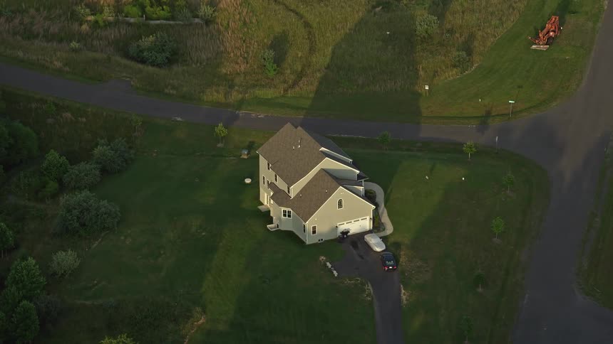 Aerial footage of a charming residential property surrounded by pristine green lawns at dusk located in Manassas Virginia showcasing the splendid sunset over the East Coast countryside