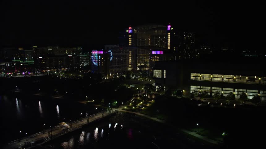 An aerial stock footage of the night view of National Harbor Maryland showing the pier and Gaylord National Resort & Convention Center