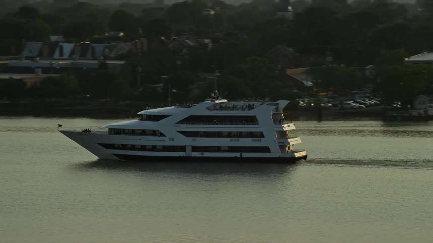 An aerial clip tracking a ferry as it sails the Potomac River during sunset in Alexandria Virginia